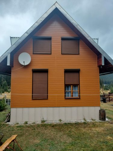 Panou decorativ de exterior cu aspect de lemn montat pe fațada unei case, fotografie trimisă de un client PANEL PLUS